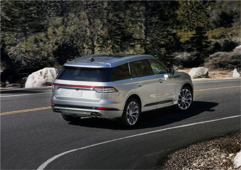 A 2023 Lincoln Aviator® Grand Touring model is shown being driven on a tight turn of a mountain road | Kindle Lincoln in Cape May Court House NJ