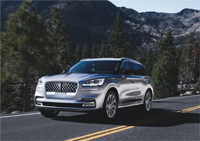 A 2023 Lincoln Aviator® Grand Touring SUV being driven on a winding road to demonstrate the capabilities of all-wheel drive | Kindle Lincoln in Cape May Court House NJ