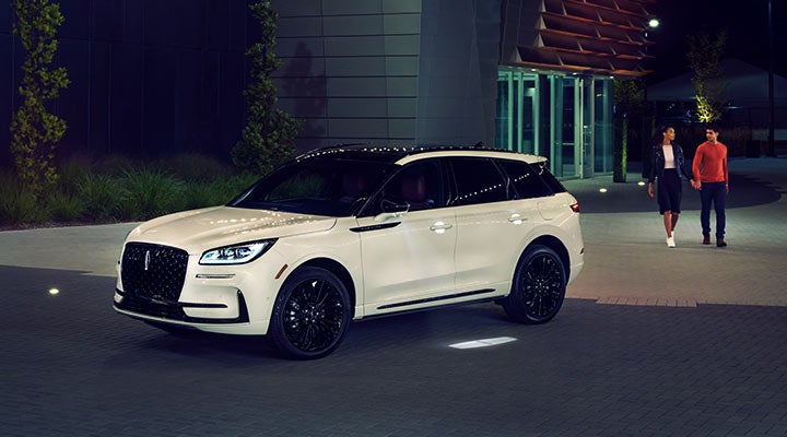 Two people approach a 2024 Lincoln Corsair® SUV featuring the available Jet Appearance Package.