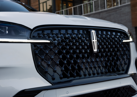 The black grille of a white 2025 Lincoln Aviator® SUV is shown with its fog lights on. | Kindle Lincoln in Cape May Court House NJ